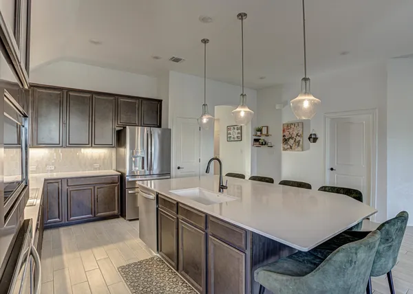 a kitchen with stainless steel appliances granite countertop a sink a stove and a refrigerator