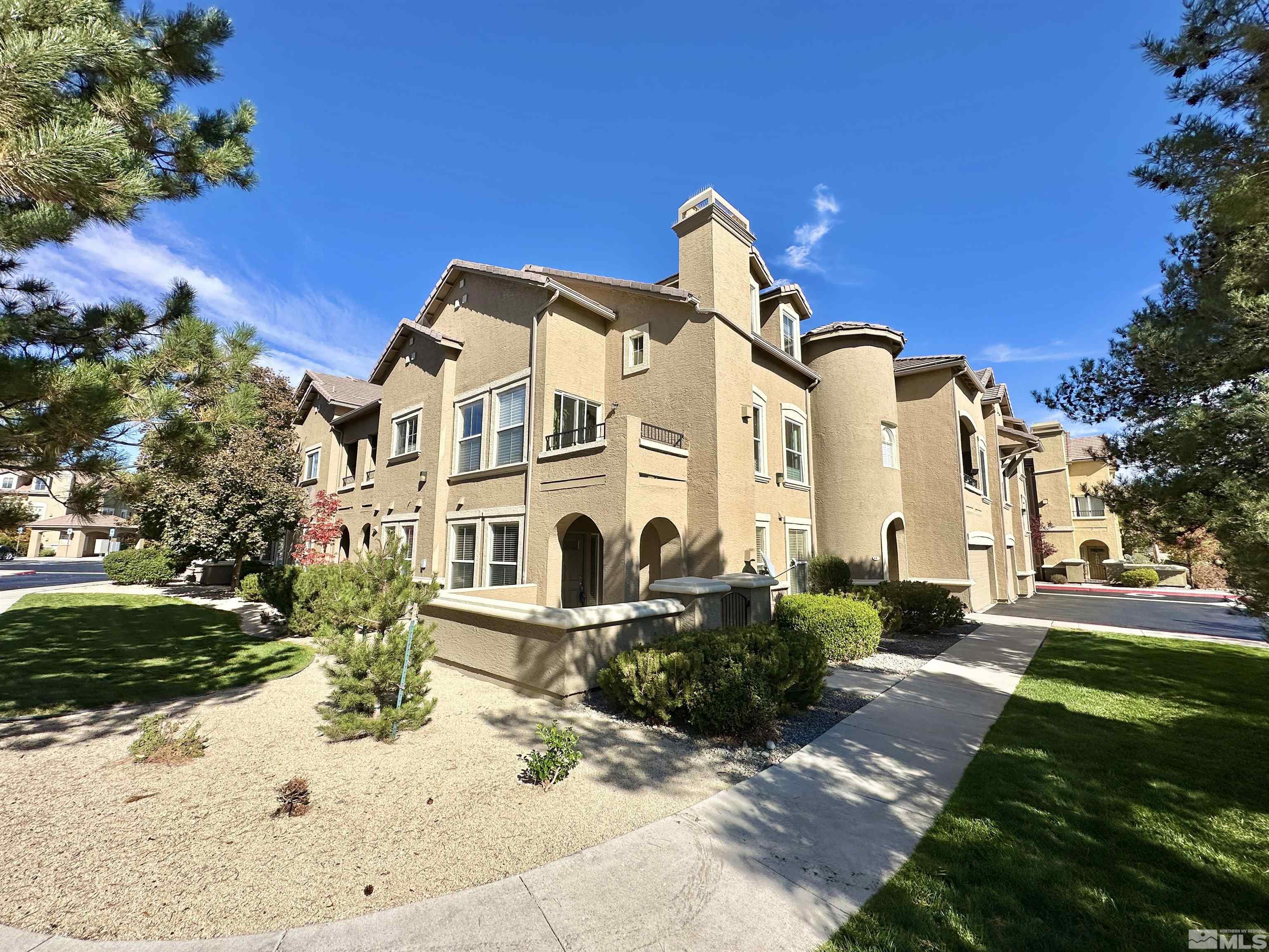 9050 Double R Boulevard, Unit 311 Reno, NV 89521 - Photo 1 of 37 a front view of a house with a yard