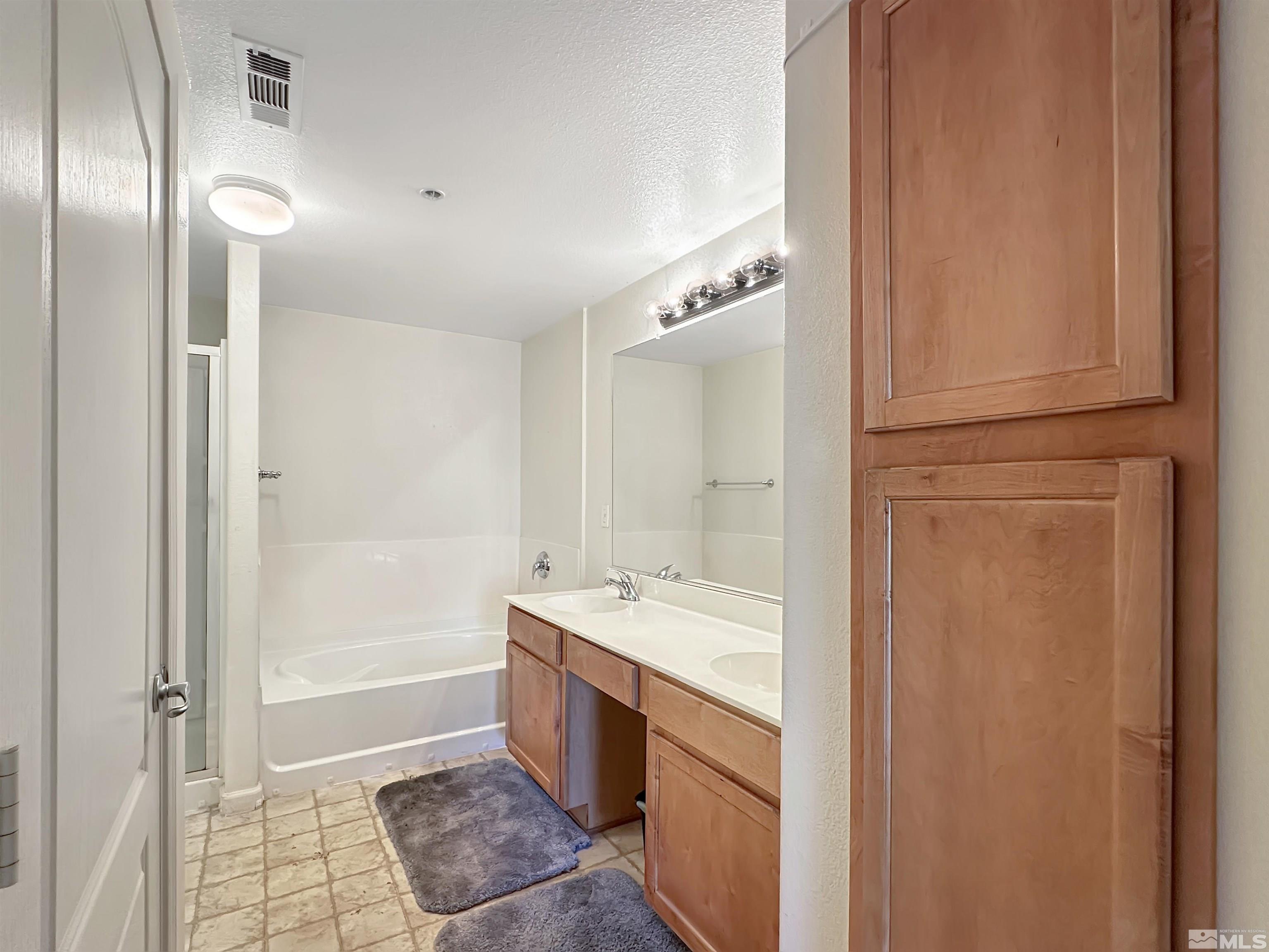 9050 Double R Boulevard, Unit 311 Reno, NV 89521 - Photo 18 of 37 a spacious bathroom with a bathtub sink and mirror