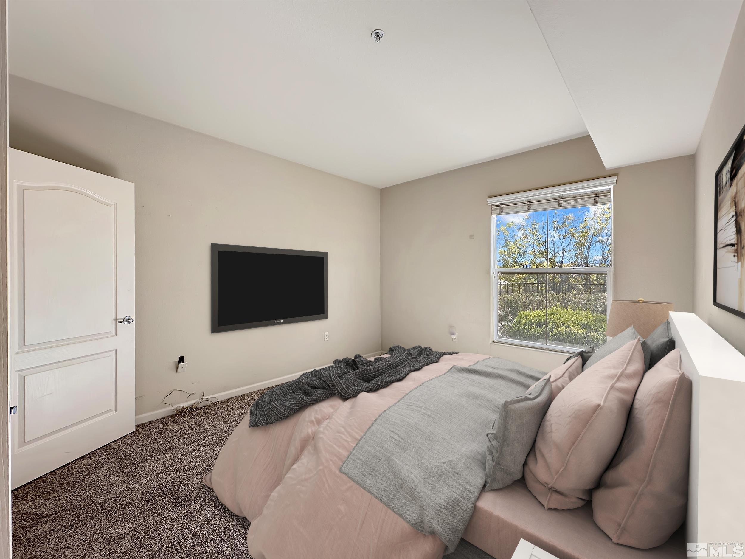 9050 Double R Boulevard, Unit 311 Reno, NV 89521 - Photo 20 of 37 a bedroom with a bed and a flat screen tv