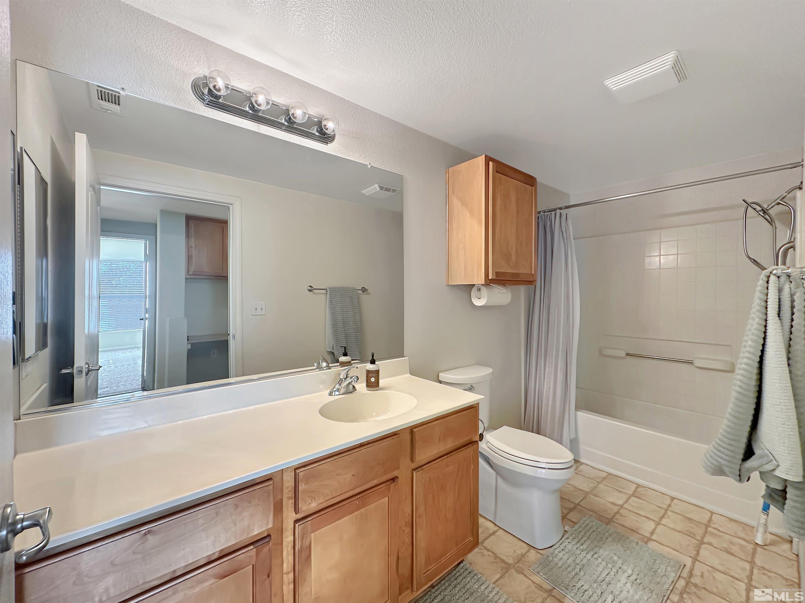 9050 Double R Boulevard, Unit 311 Reno, NV 89521 - Photo 22 of 37 a bathroom with a sink a toilet and shower