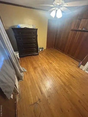 a view of an empty room with a chandelier fan