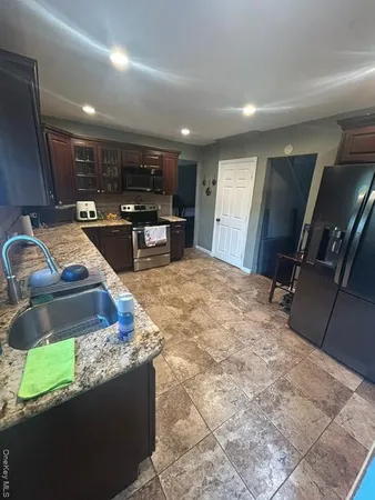 a kitchen with stainless steel appliances granite countertop a sink a stove and a refrigerator