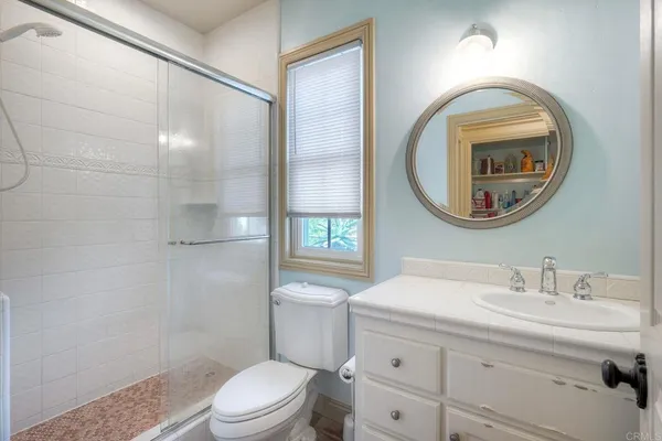 a bathroom with a toilet a sink and a mirror
