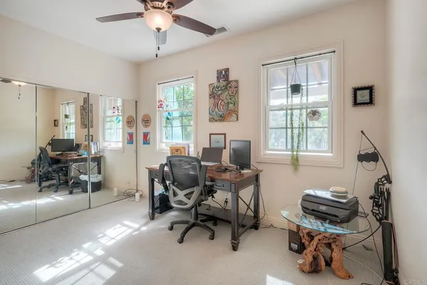 a view of a workspace with furniture and a window