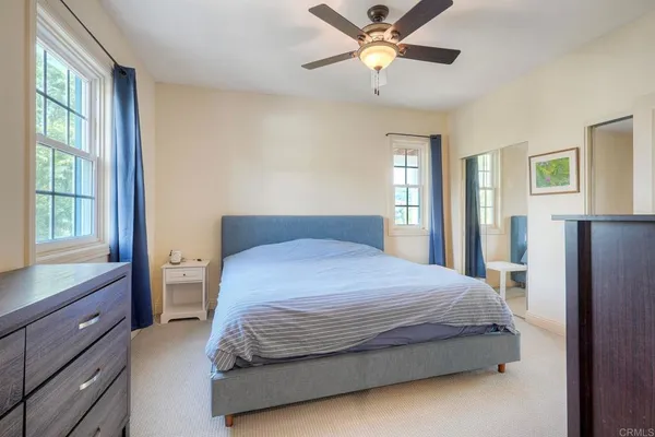 a bedroom with a large bed and a chandelier