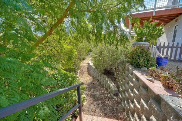 a view of a yard with plants and wooden fence