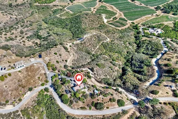 an aerial view of a house with a yard and greenery