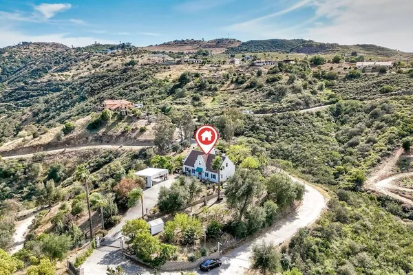 an aerial view of house with yard and mountain view in back