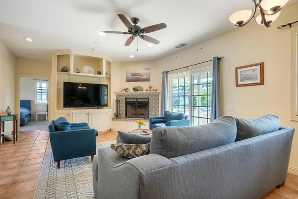 a living room with furniture a flat screen tv and a fireplace