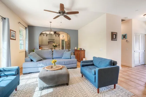 a living room with furniture ceiling fan and a rug