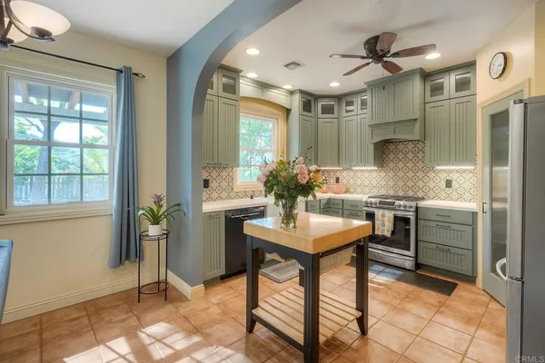 a kitchen with stainless steel appliances kitchen island granite countertop furniture and a refrigerator