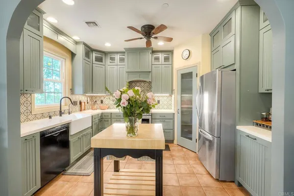 a kitchen with stainless steel appliances kitchen island granite countertop a refrigerator and a sink