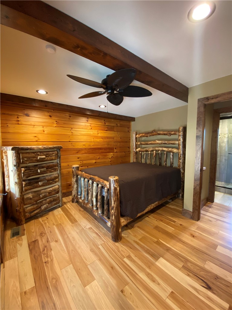 128 McAlister Road West Union, SC 29696 - Photo 8 of 40 Natural wood tones and exposed beams define this inviting and comfortable bedroom space.