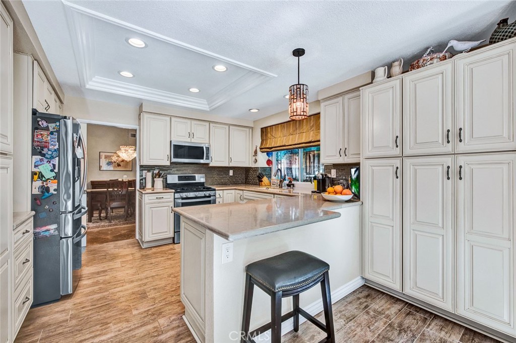 7214 East Wrangler Circle Orange, CA 92869 - Photo 26 of 69 a kitchen with granite countertop a refrigerator a stove top oven a sink and cabinets