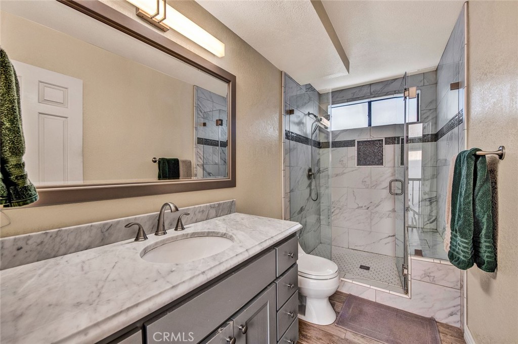 7214 East Wrangler Circle Orange, CA 92869 - Photo 54 of 69 a bathroom with a granite countertop toilet a sink and a shower