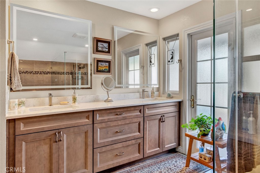 7214 East Wrangler Circle Orange, CA 92869 - Photo 58 of 69 a bathroom with a granite countertop sink a mirror and a shower