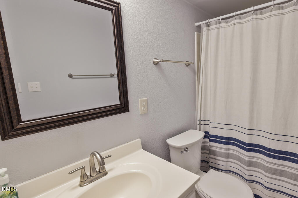 2831 Edridge Court, Unit 202 Raleigh, NC 27612 - Photo 18 of 33 a bathroom with a sink a toilet and mirror