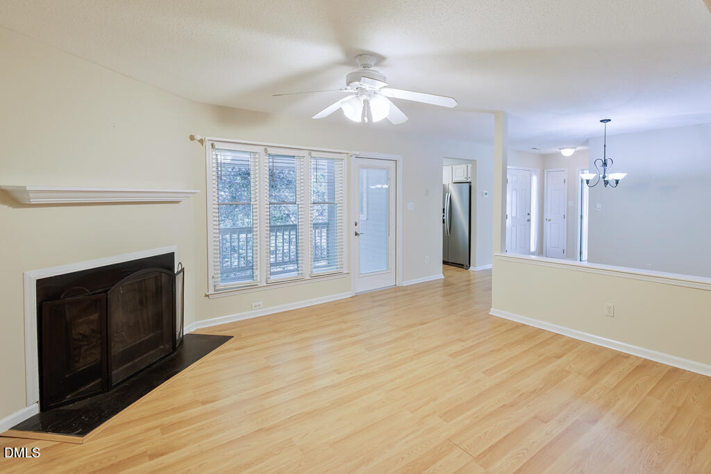 2831 Edridge Court, Unit 202 Raleigh, NC 27612 - Photo 8 of 33 a view of an empty room with chandelier and fireplace