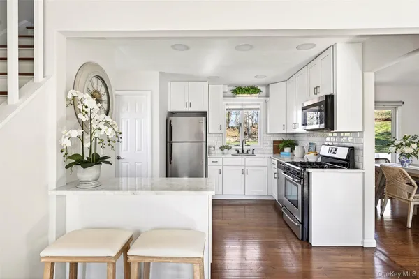a kitchen with stainless steel appliances white cabinets and a window