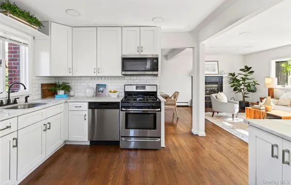 a kitchen with stainless steel appliances a stove a sink a refrigerator a stove a microwave and cabinets