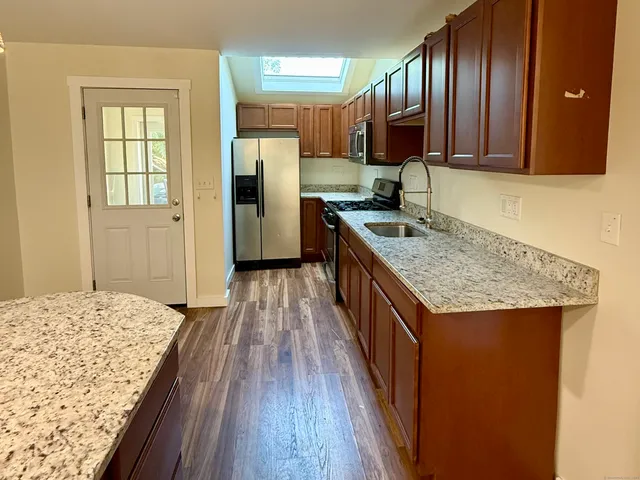 a kitchen with granite countertop a sink stove and refrigerator