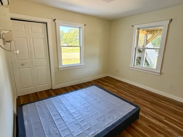 a wooden bench sitting in a bedroom next to a window