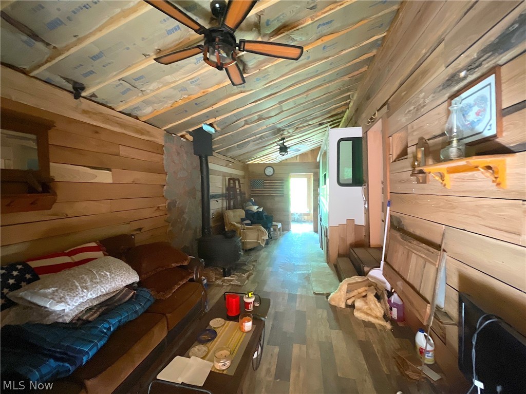 35173 Merrill Ridge Road Graysville, OH 45734 - Photo 8 of 23 Bedroom featuring wood walls, hardwood / wood-style floors, a wood stove, and lofted ceiling