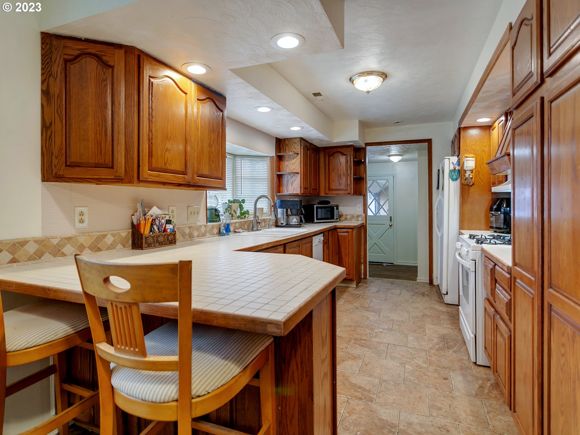 6701 Southeast Hazel Street Portland, OR 97206 - Photo 6 of 20 a kitchen with a dining table chairs and refrigerator