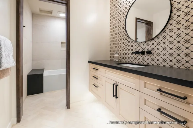 a bedroom with a bed and a lamp on dresser