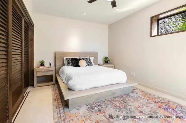 a bed sitting in a spacious bedroom next to a window