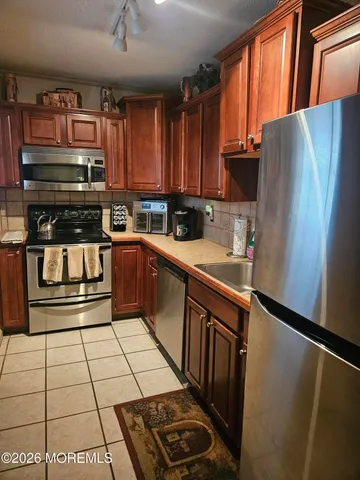 a kitchen with stainless steel appliances a refrigerator sink and cabinets