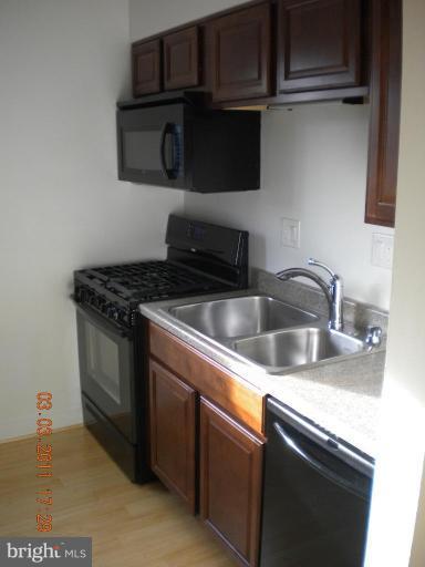 11507 Amherst Avenue, Unit 101 Silver Spring, MD 20902 - Photo 2 of 6 a kitchen with stainless steel appliances granite countertop a sink stove and microwave