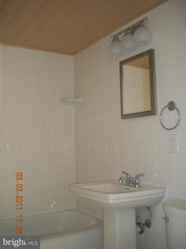 11507 Amherst Avenue, Unit 101 Silver Spring, MD 20902 - Photo 3 of 6 a bathroom with a sink a mirror and shower