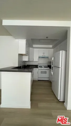 a kitchen with a refrigerator sink and cabinets