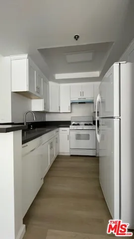a kitchen with stainless steel appliances a refrigerator sink and white cabinets