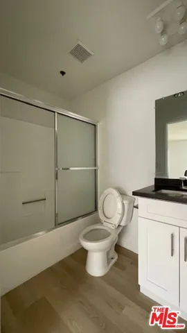 a bathroom with a granite countertop toilet and a sink