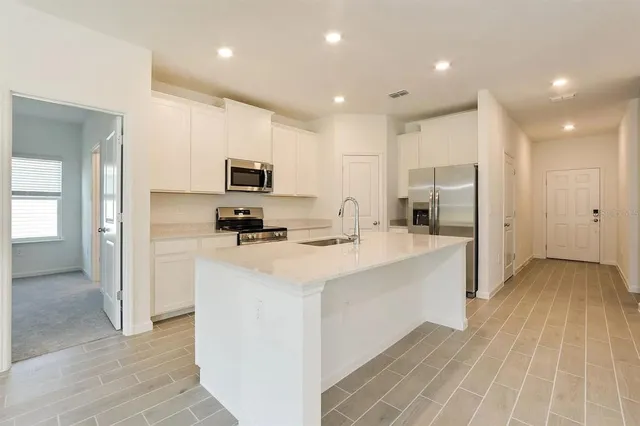 a kitchen with stainless steel appliances a refrigerator sink and microwave