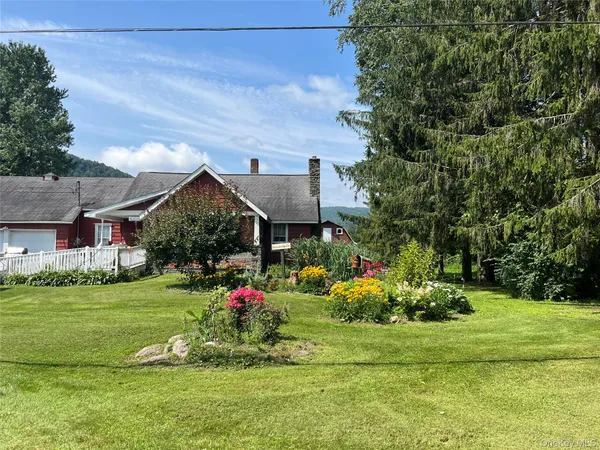 a view of a house next to a big yard and potted plants