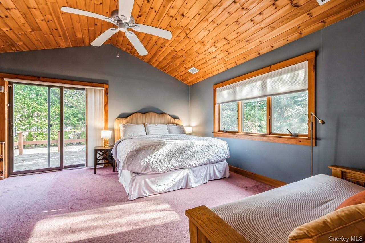 292 Little Fresh Pond Road Southampton, NY 11968 - Photo 26 of 46 Primary bedroom featuring access to back deck, ceiling fan, wood ceiling, and high ceiling