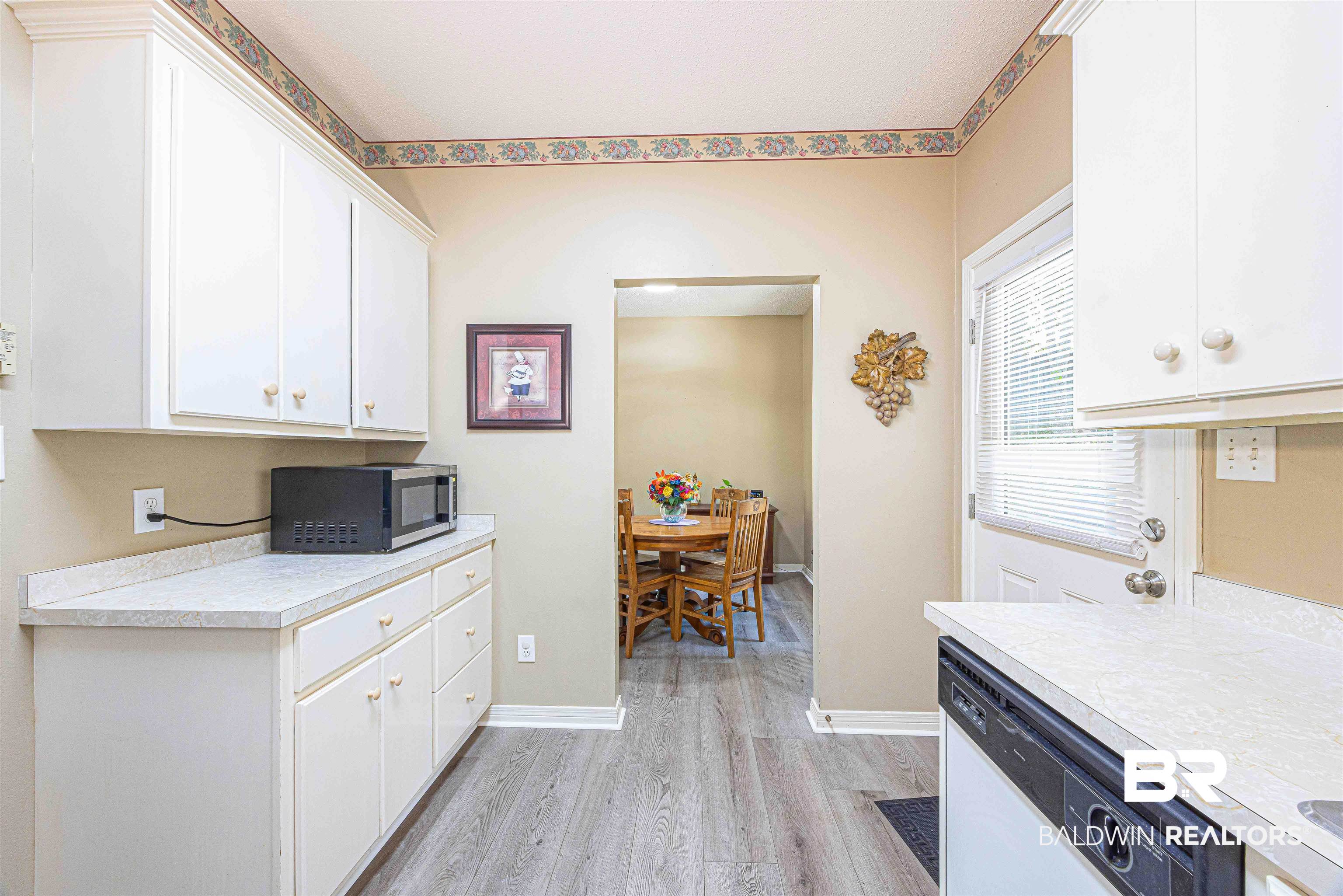 175 Montclair Loop Daphne, AL 36526 - Photo 15 of 44 Kitchen with light countertops, light wood-type flooring, dishwasher, and white cabinets