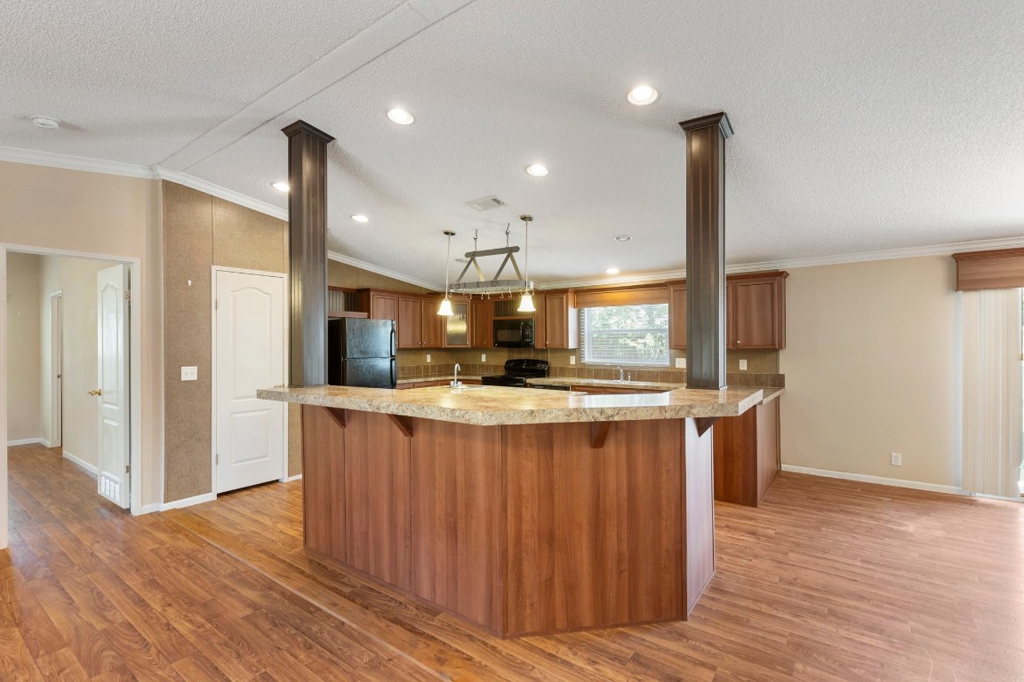 25330 Settlers Mill Road Magnolia, TX 77355 - Photo 11 of 21 a kitchen with stainless steel appliances granite countertop wooden floors a sink and a refrigerator