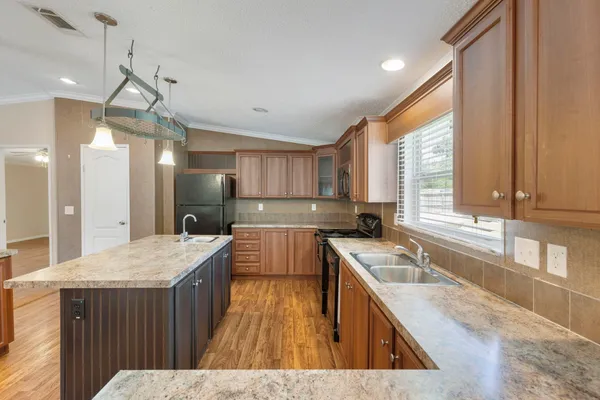 a kitchen with a stove a sink a center island and a window