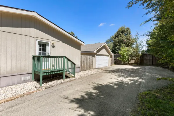 a view of a house with a yard and wooden fence