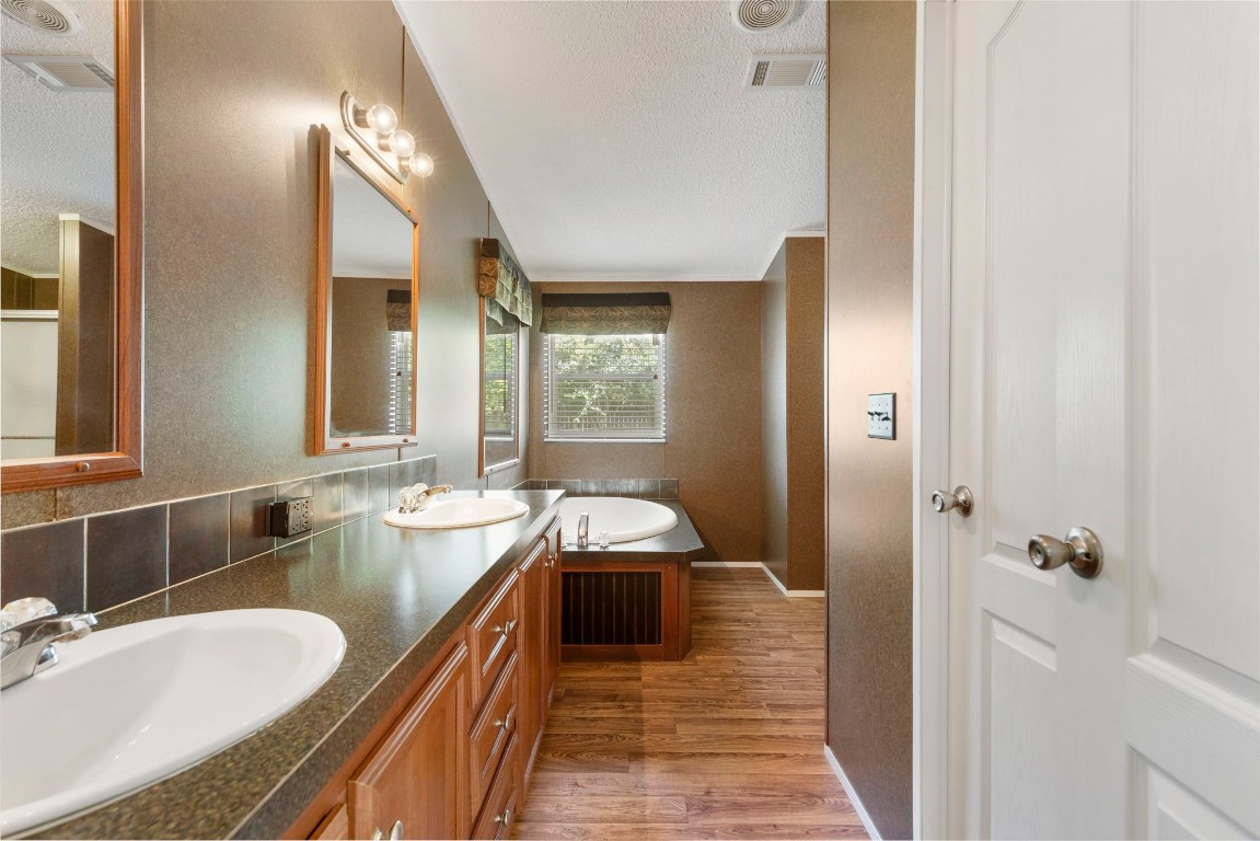 25330 Settlers Mill Road Magnolia, TX 77355 - Photo 7 of 21 a spacious bathroom with a granite countertop double vanity sink a mirror and a shower
