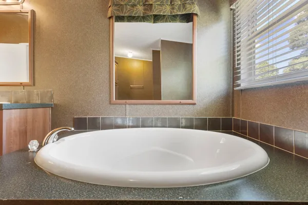 a white bath tub sitting in a bathroom next to a window