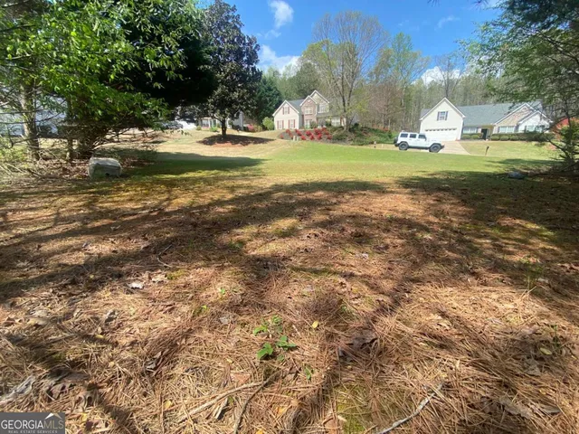 a view of a fountain in front of a house with a yard