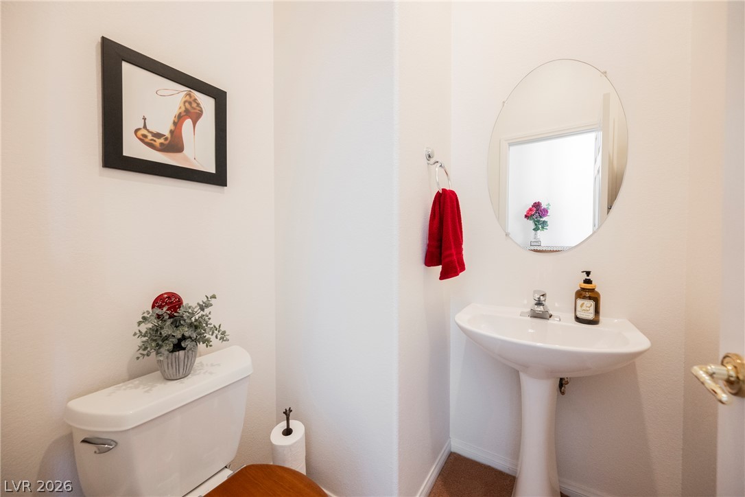 5494 Pine Ranch Street Las Vegas, NV 89113 - Photo 39 of 54 A well-appointed powder room with a modern pedestal sink.