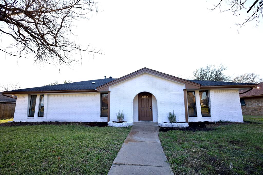 Ranch-style home with a front lawn and brick siding