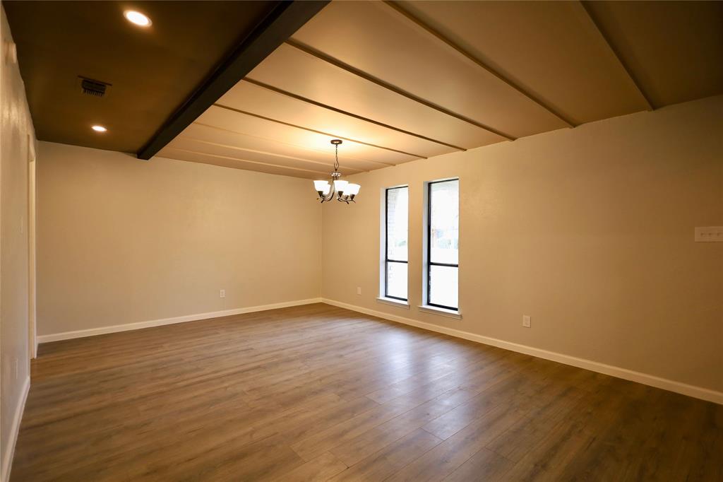 905 Pine Tree Lane DeSoto, TX 75115 - Photo 2 of 11 Unfurnished room with a chandelier, dark wood-style flooring, recessed lighting, and beam ceiling